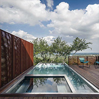 Diamond Spas stainless steel pool and spa with glass wall featured in a stunning home in Austin, Texas