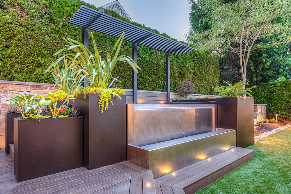 Stainless steel spa with bench seating, interior descending stairway, LED lighting, infinity edge water feature and catch basin.  100”x149”x48”