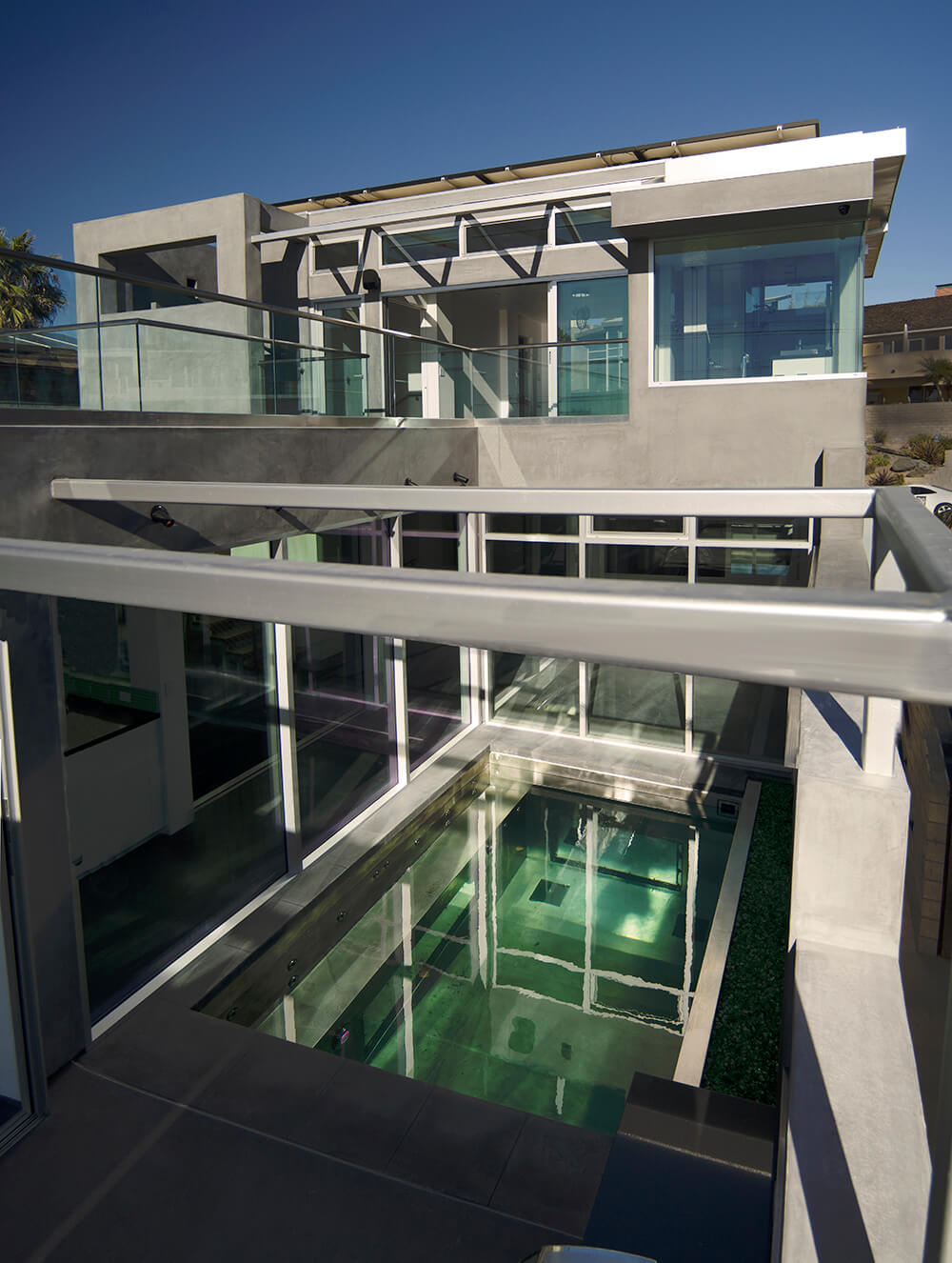 Custom Stainless Steel Swimming Pool with 3 Acrylic Panels for Viewing the Interior of the Pool from Inside the Home, LED Lighting, Entry Stairway, Built in Seating, Back Fire Wall Feature, Water Wall Feature and Automatic Safety Cover 180