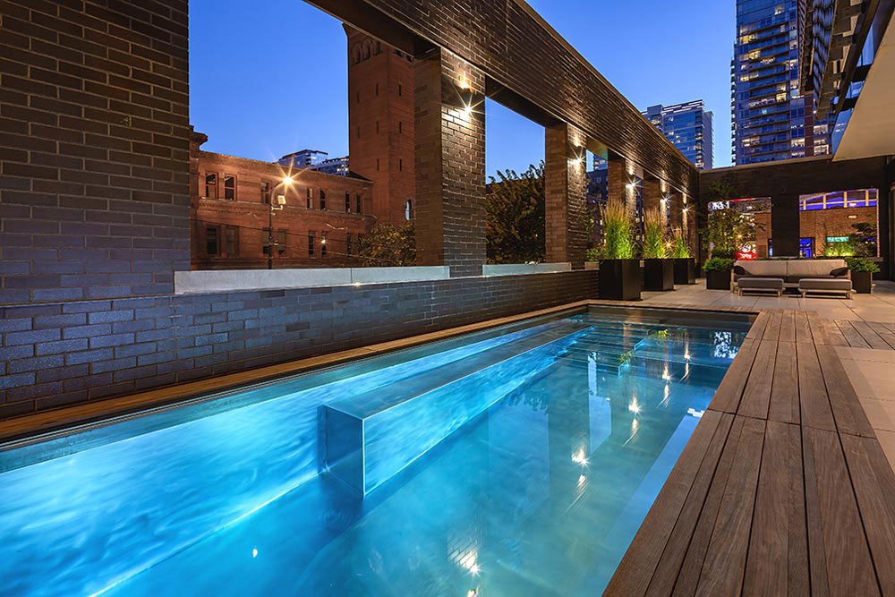 Stainless steel pool with interior stairway, bench seating on side walls, LED lighting and automatic cover. 115”x304”x65”