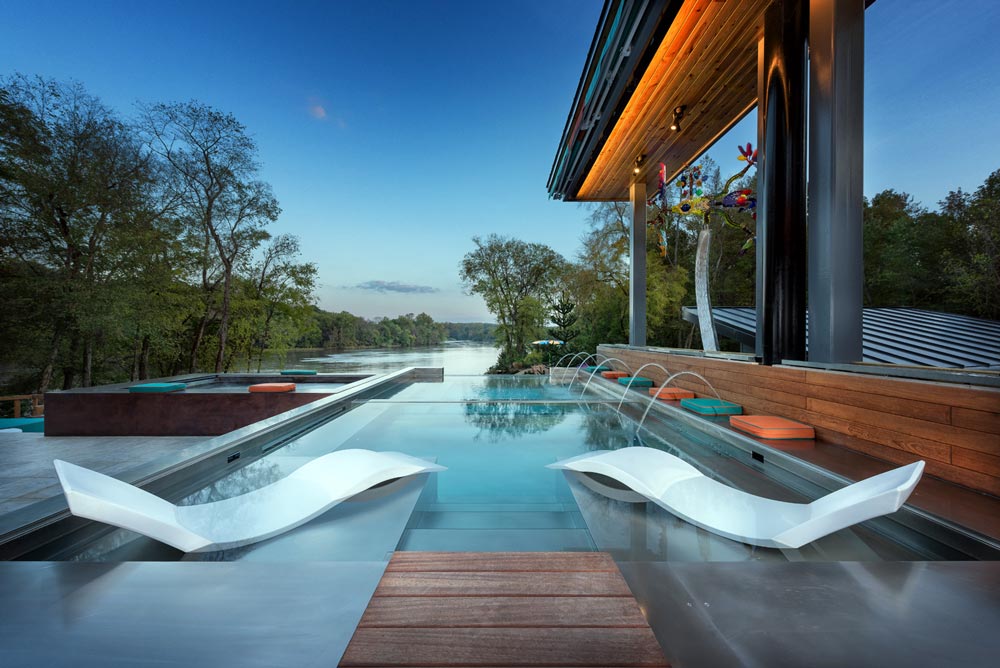 Custom stainless steel pool with sun shelf, descending stairway, bench seating and laminar jets.  Glass windows separates pool and neighboring stainless steel and copper spas with vanishing edge. 