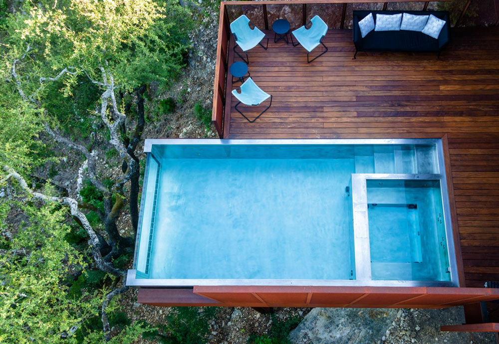  Stainless steel pool and spa combo with descending stairway.  Pool has  glass wall at end and cantilevers out over mountain side below.  137”x280”x55”