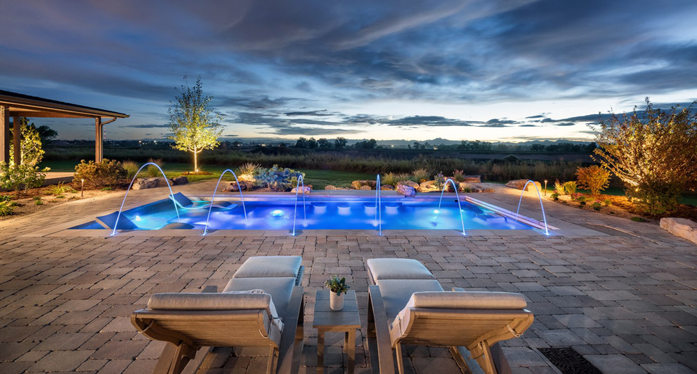 Stainless steel pool with sun shelf, bench seating on side walls of pool, swim up bar, swim spa, laminar jets, and automatic cover.  193”x402”x69”