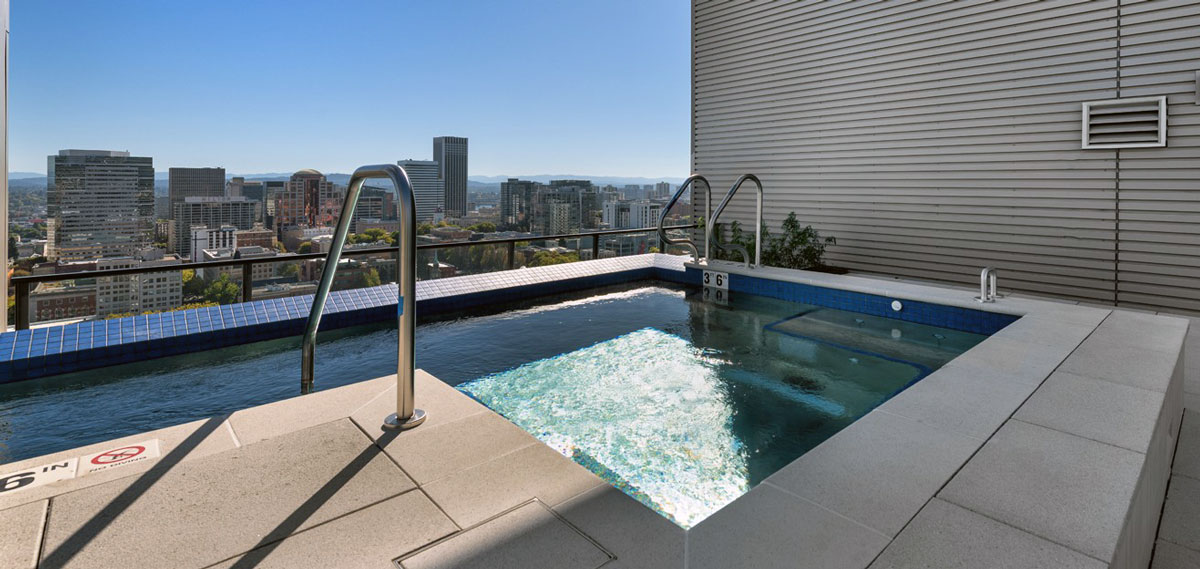 Stainless steel pool / spa with bench seating, interior stairway, and LED lighting.