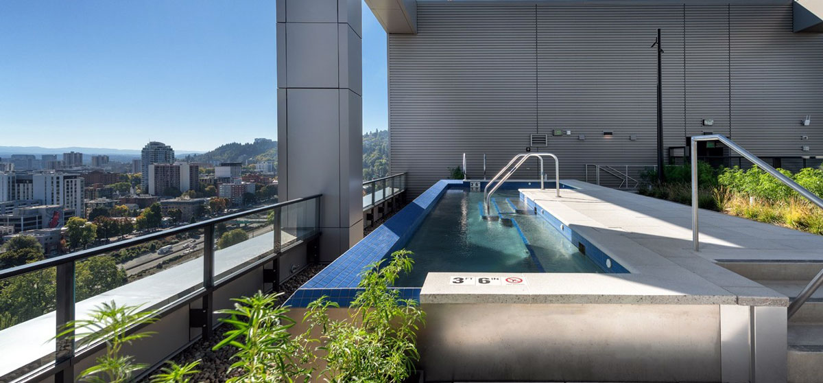 Stainless steel pool / spa with bench seating, interior stairway, and LED lighting.